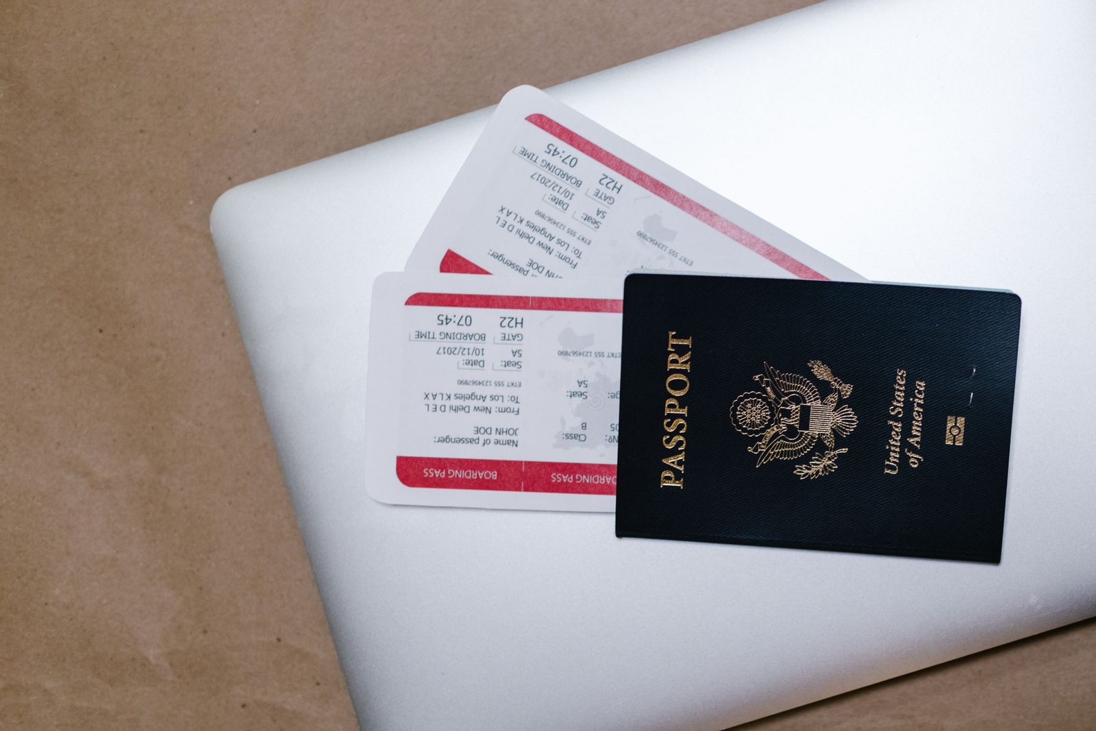 Passport and airline tickets resting on a laptop